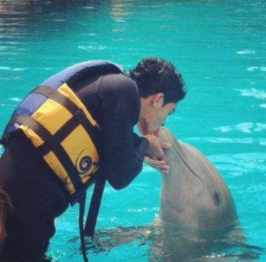 Arya Jimenez father Raul Jimenez with a dolphin.